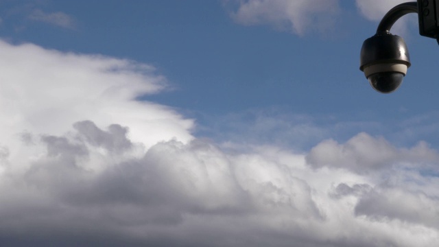 一栋建筑上的监控摄像头拍摄到的画面，背景是蓝天白云……视频下载