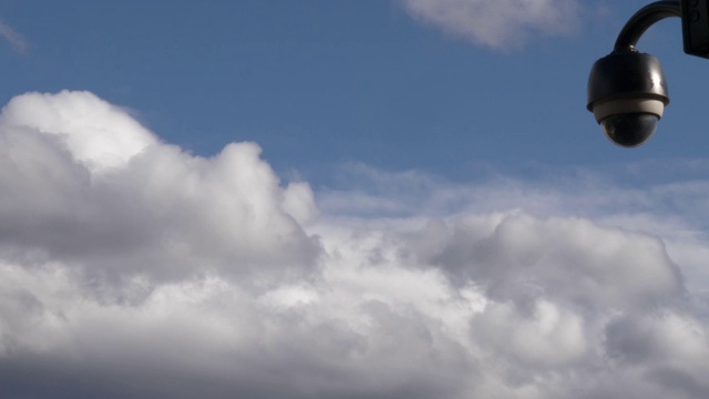 一栋建筑上的监控摄像头拍摄到的画面，背景是蓝天白云……视频下载