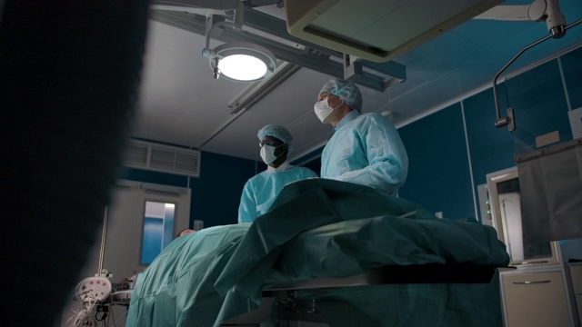 两个外科医生移动一台x光机进行手术视频素材