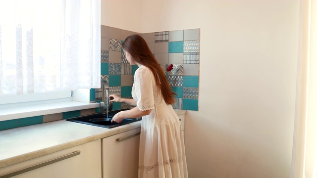 穿白裙子的女孩洗平底锅。视频素材