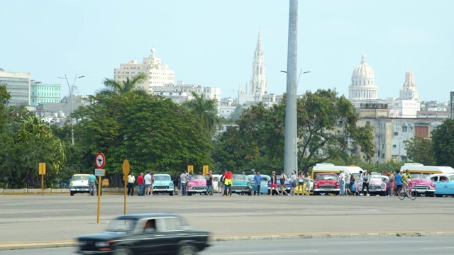 古巴哈瓦那老爷车展。游客租用他们作为出租车。以Capitolio和天际线为背景进行拍摄视频下载