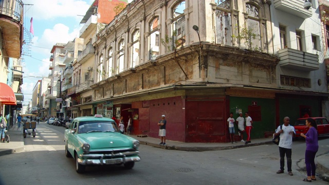 哈瓦那Centro街。老建筑，说话的人，还有老爷车。古巴b - roll视频下载