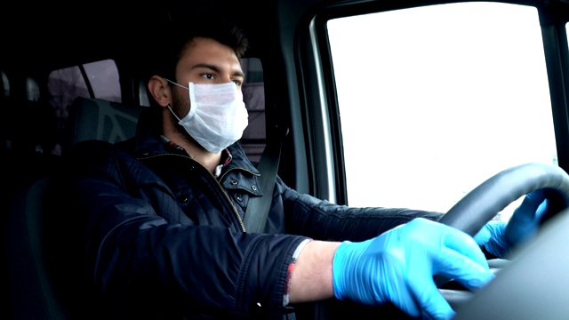 戴着面罩和手套开车的男人。预防冠状病毒。视频下载