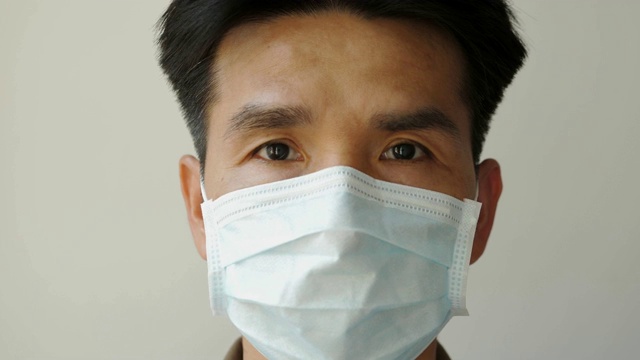亚洲男人戴着口罩，他点头听着有关当前疾病的信息。视频素材
