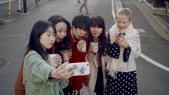 一群新潮的日本年轻人喝着珍珠奶茶自拍视频素材