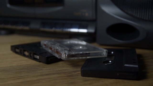 木桌上放着一些旧录音带和一个播放器视频素材