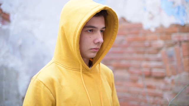 一个穿着黄色运动衫的少年看着他的前面视频素材
