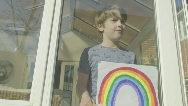 一个男孩举着彩虹的图像视频下载