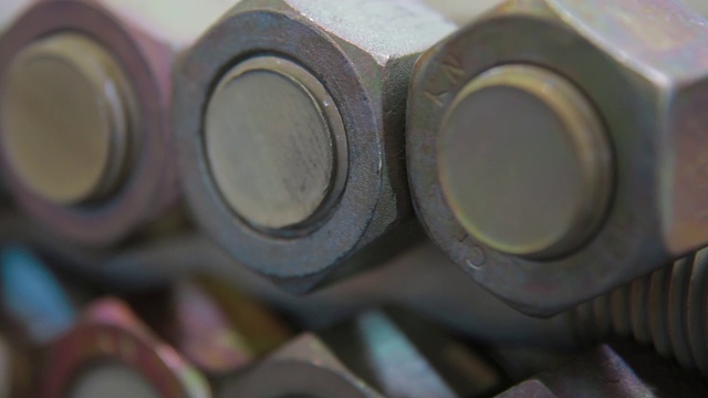 现代工厂工业生产线上的带螺母的钢螺钉。螺丝生产特写镜头视频素材