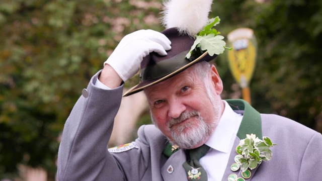 慕尼黑啤酒节传统服装游行男子与羽毛帽子欢迎相机视频下载
