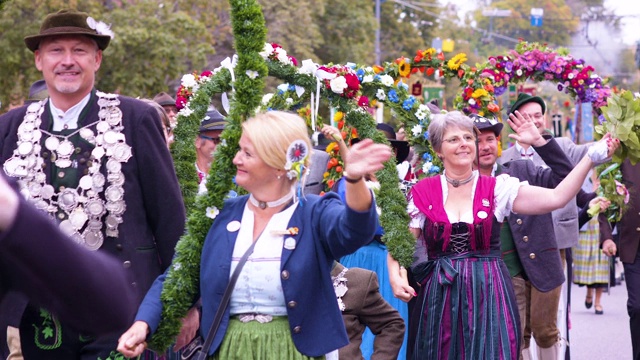 慕尼黑啤酒节传统服装游行，男女手持花圈行走视频素材