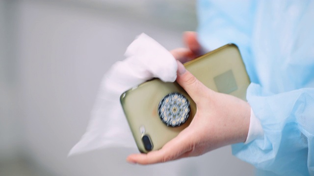 女人用消毒纸巾给手机消毒。视频下载