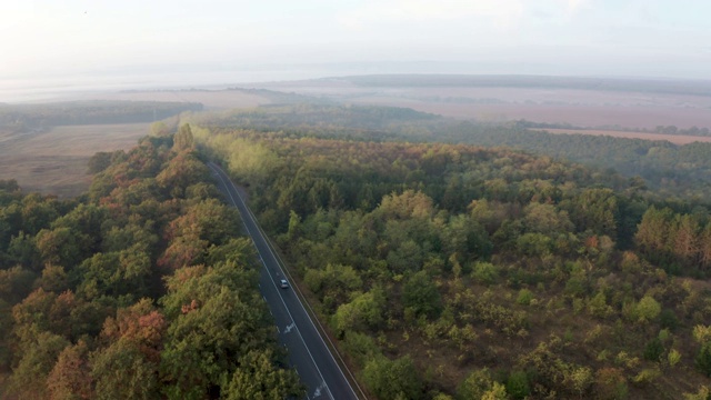 鸟瞰图与丰富多彩的秋天森林与道路和汽车视频下载