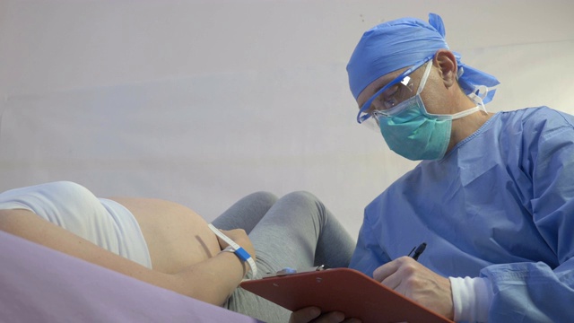 一位年轻的孕妇正在接受外科医生的检查视频下载
