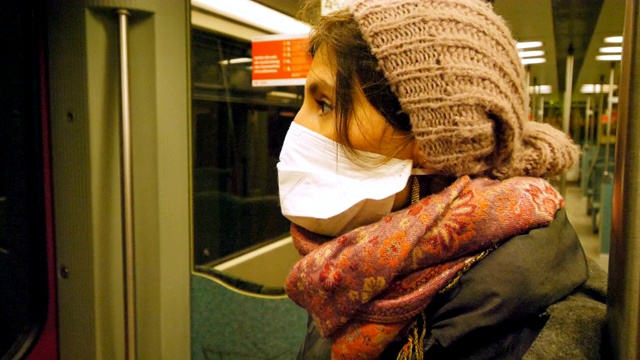 戴着面具坐地铁的年轻女子视频素材
