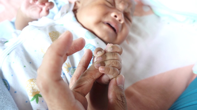 新生的婴儿牵着父亲的手视频素材