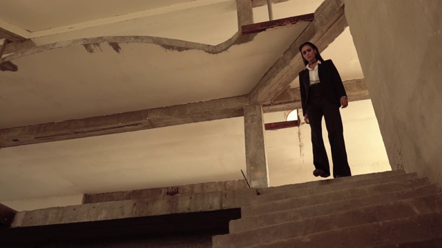 一个女人走在废墟里的楼梯上视频素材