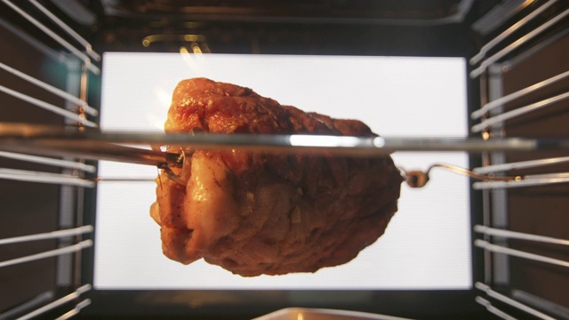 将烤猪肉放在烤肉叉上，放在热对流烤箱中烘烤一段时间视频下载