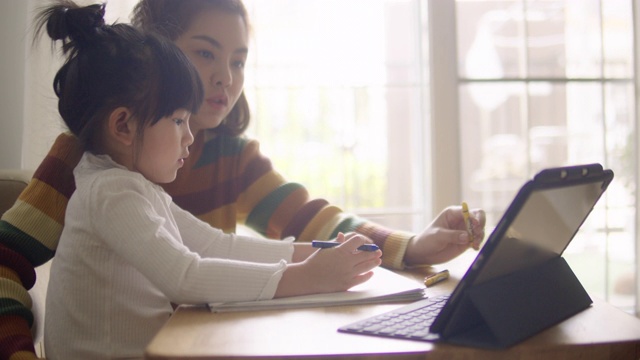 亚裔女儿在家和母亲一起参加网络课程。视频下载