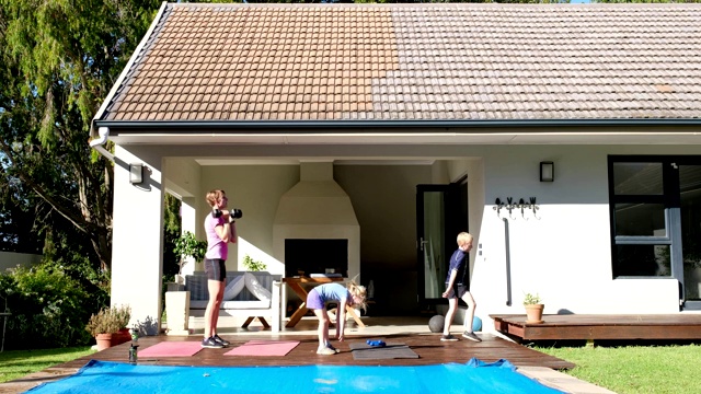 一家人在他们的花园里做一个有趣的例行锻炼视频素材