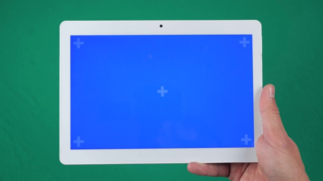 水平平板在手近距离隔离在绿色背景。平板屏幕为蓝色色键，背景为绿色色键。视频下载