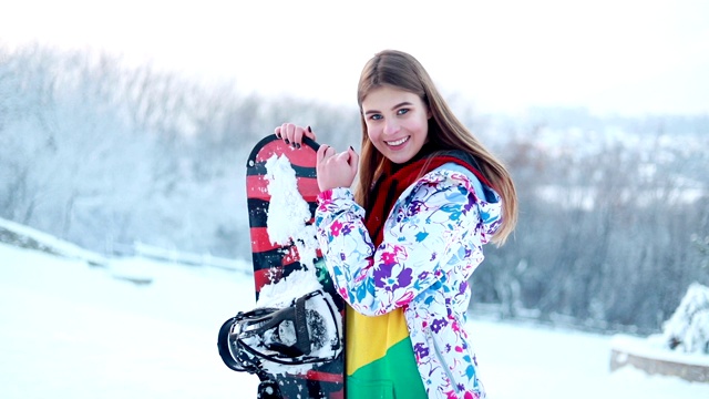 微笑美丽的女人与她的滑雪板摆姿势视频下载