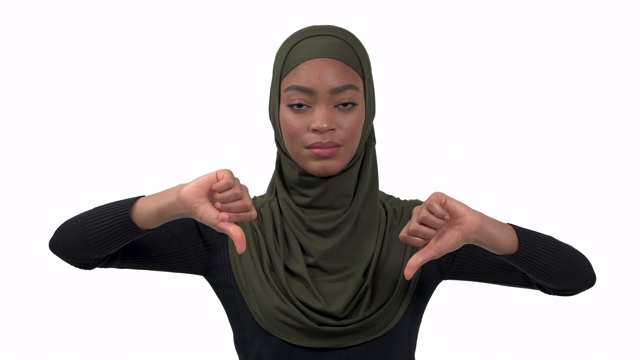 一个非洲妇女的特写照片显示她的拇指向下。消极情绪的表达，手势的概念。孤立，在白色背景上视频下载