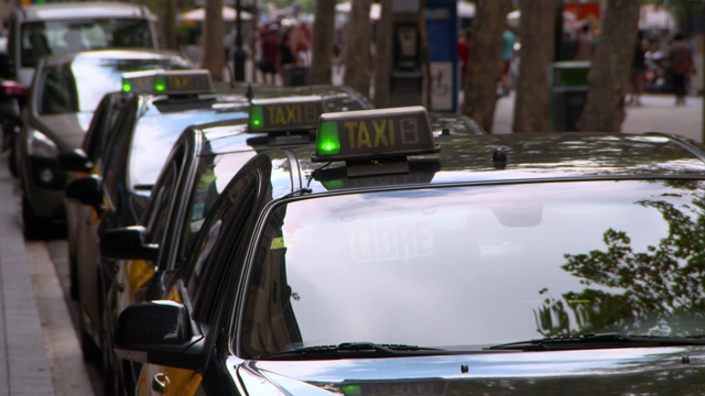 西班牙巴塞罗那，一辆出租车排成一排停在街道上视频下载