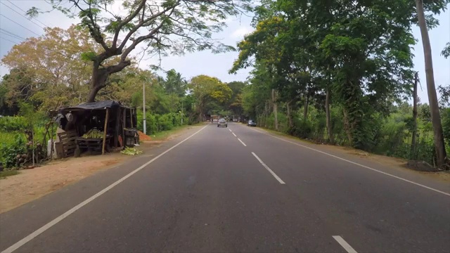 在阳光明媚的日子里，阿鲁甘湾，斯里兰卡，海上街道上的车辆的延时拍摄视频下载