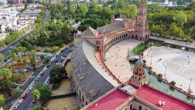 航拍游客在城市街道旁的著名广场，无人机向前飞过地标——西班牙塞维利亚视频素材