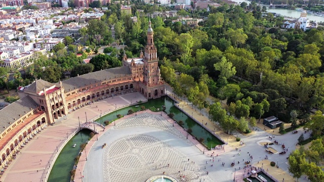 航拍拍摄游客在城市著名广场喷泉周围，无人机在西班牙塞维利亚广场上空飞行视频素材