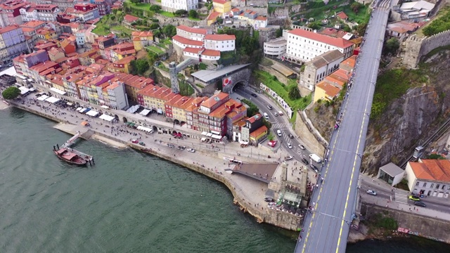 航拍河上的著名桥梁，城市里的建筑，无人机向前飞向游客和街道上的车辆——葡萄牙波尔图视频下载