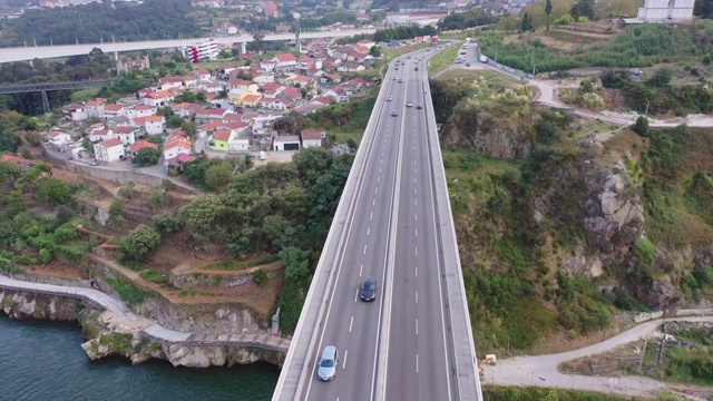 空中倾斜拍摄河上大桥上的车辆，无人机在葡萄牙波尔图城市上空飞行视频下载