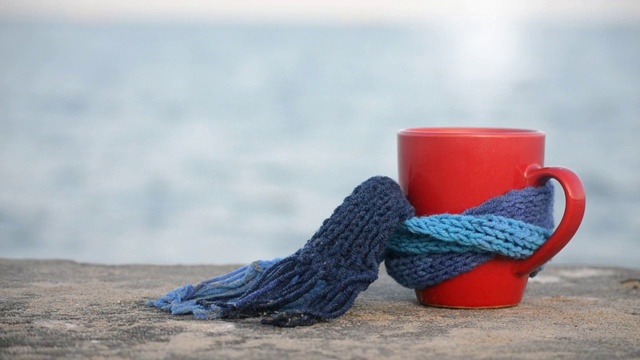 红杯，热咖啡和蒸汽茶，系蓝色针织围巾视频下载