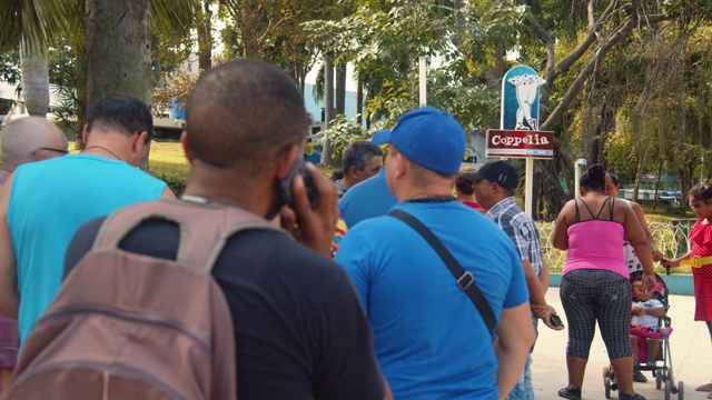 古巴人在Coppelia冰淇淋店门口等候。一台老爷车停,哈瓦那视频下载