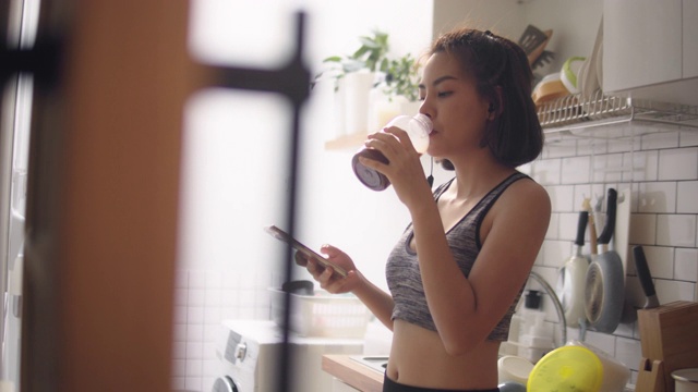 在家锻炼后喝蛋白质奶昔的健康女性视频下载