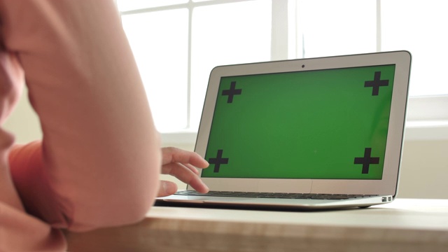 特写女子使用绿色屏幕的笔记本电脑视频素材