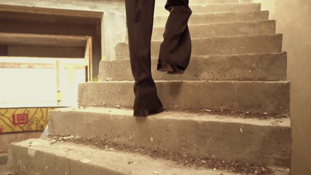 一个陌生的女人走在废弃的房子里的楼梯上视频素材