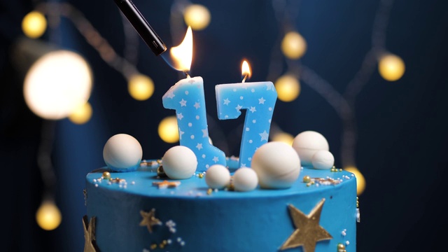 生日蛋糕号17星星天空和月亮概念，蓝色蜡烛是火由打火机然后吹灭。如果需要，在屏幕右侧复制空间。特写和慢动作视频下载