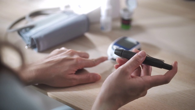 妇女糖尿病患者在家里用血糖仪检测血糖视频下载