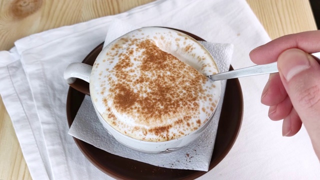 卡布奇诺或拿铁咖啡。用勺子舀牛奶从咖啡中起泡视频素材