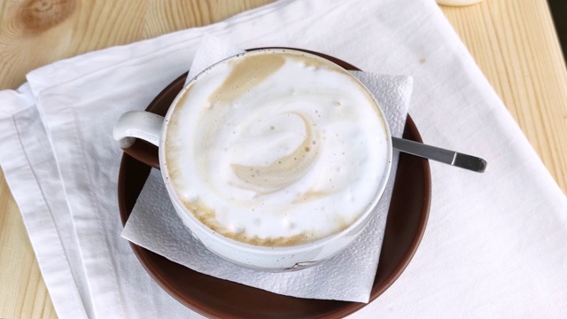卡布奇诺或拿铁咖啡。圆杯咖啡和牛奶泡沫视频素材