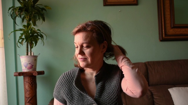 一个中年妇女在她的客厅里的肖像视频素材
