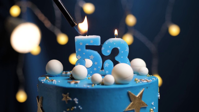 53号生日蛋糕星星天空和月亮概念，蓝色蜡烛是火由打火机然后吹灭。如果需要，在屏幕右侧复制空间。特写和慢动作视频下载