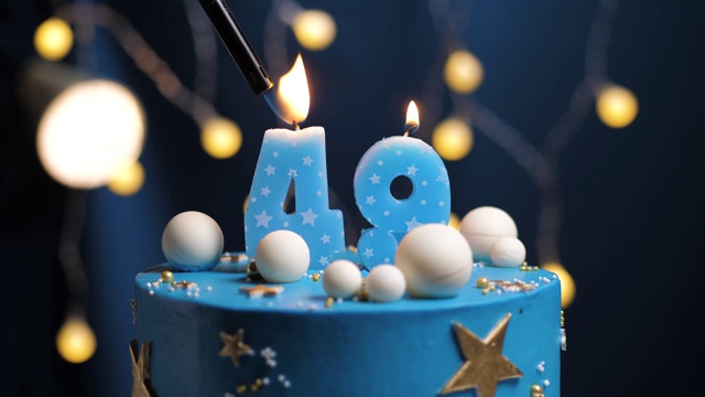 49号生日蛋糕星星天空和月亮概念，蓝色蜡烛是火由打火机然后吹灭。如果需要，在屏幕右侧复制空间。特写和慢动作视频下载