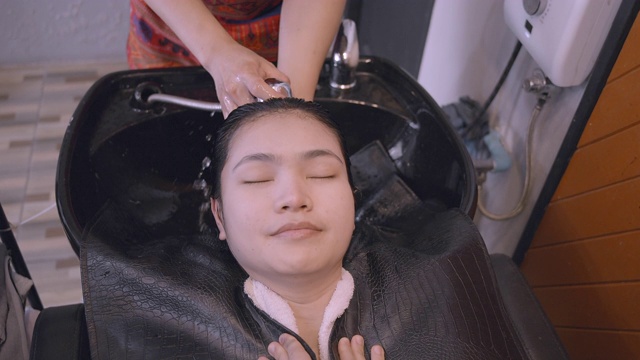 美丽的女人她使用美发沙龙的洗头服务。视频素材