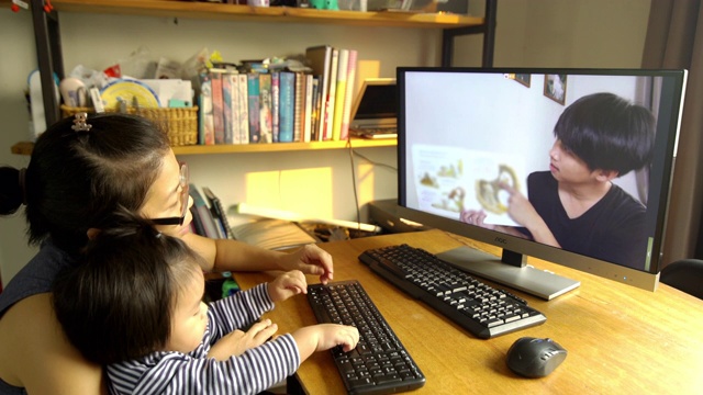 亚洲家庭学生在家里通过电脑学习视频素材