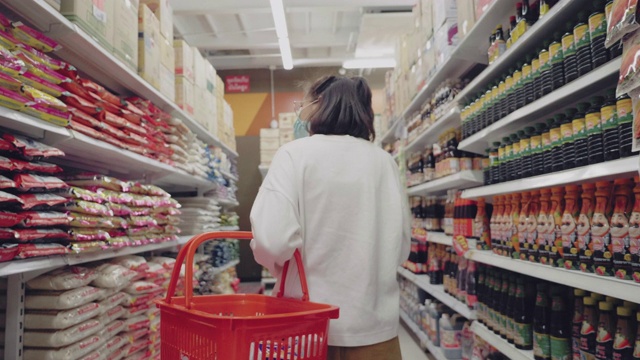 年轻女子戴着口罩在超市买干货视频下载