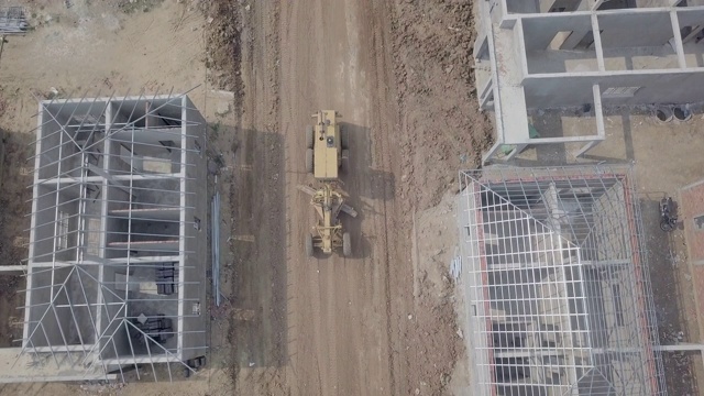 无人机拍摄的是一架平地机在建筑工地工作的画面视频素材
