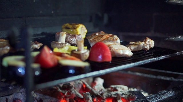 烹饪上煤。西葫芦，茄子，蘑菇，西红柿，辣椒。厨师在烤架上做饭。近距离视频素材